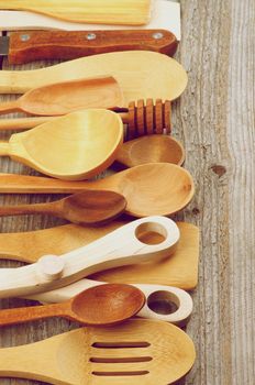 Border of Various Wooden Spoons and Cooking Utensils isolated on Rustic Wooden background. Retro Styled