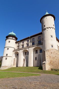 view on castle Nowy Wisnicz in Poland on a background of blue sky