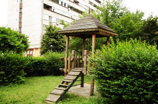 Wooden gazebo in a shady playground area of the park