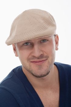 studio portrait of a young handsome man with cap, smiling