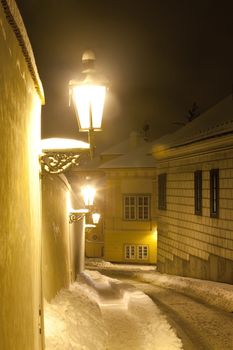 prague - narrow street at hradcany with gas lanterns in winter