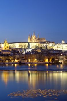 prague in winter - charles bridge and hradcany castle at dusk