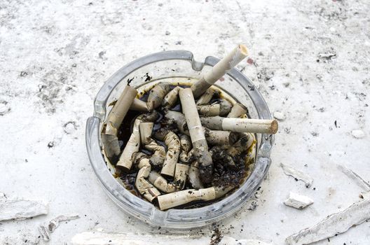 Ashtray Full of Cigarettes burnt butts wet and disgusting