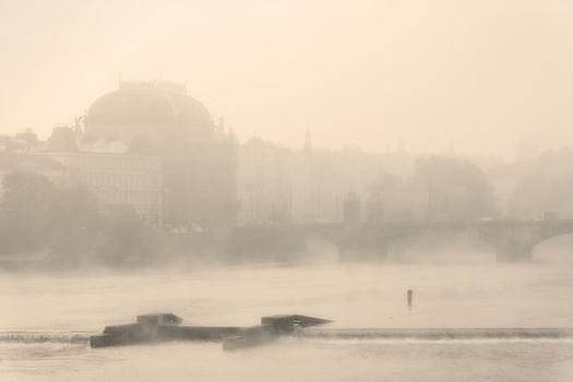 prague - national theater an vltava river at foggy morning