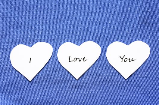 Three Paper Hearts on a Clothesline on a Textured blue Background.