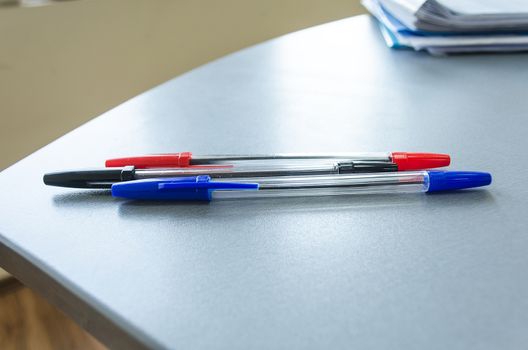 Three multicolor felt pens on wooden desk