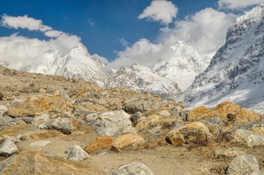 Panoramic view of snowy mountains sloping down into a rocky valley