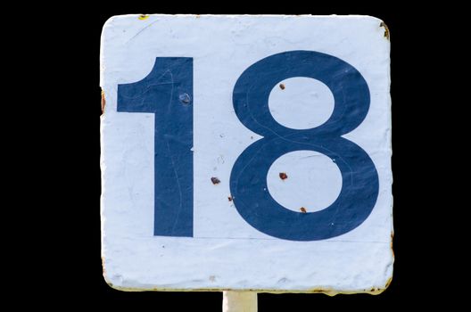 Old dirty white sign with the number 18 number on black background