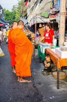 CHIANG MAI -THAILAND OCTOBER 19: People give food offerings to a Buddhist monk  on October 19, 2014 in Chiang Mai,Thailand. Thai traditional, people will make merit making by give food and something to monk