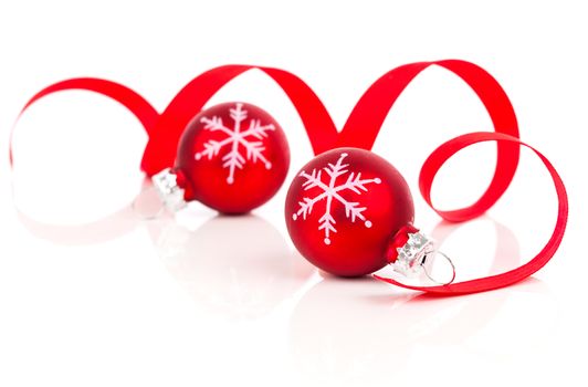 two red christmas decoration balls with satin ribbon, isolated on white background