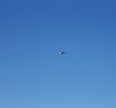 Helicopter flightning in blue sky with clouds