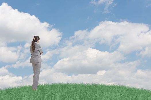 Asian business woman standing on grassland and thinking with copyspace on heaven.