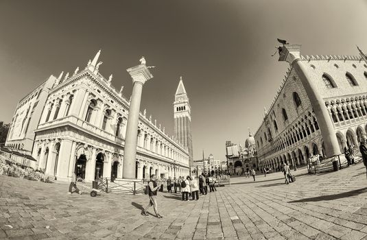 VENICE - APRIL 7, 2014: Tourists enjoy Saint Mark Square on a beautiful spring day. Venice is visted by more than 20 million people every year.