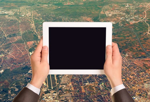 Hands holding tablet pc with empty screen. Aerial view of cityscape