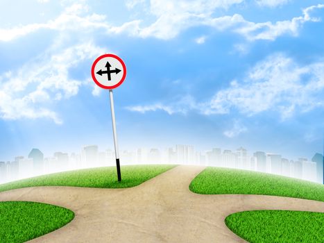 Crossroads road sign. City, green grass, fork in the way and sky as backdrop