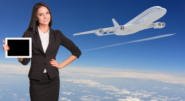 Businesswoman holding tablet pc and looking at camera. Blue sky with airplane and plane race as backdrop