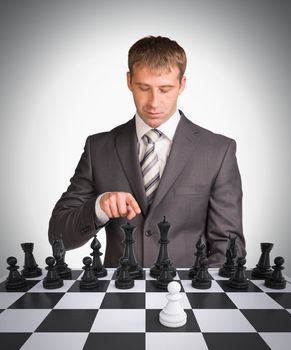 Businessman and chess board with chess. Gray background. Business concept