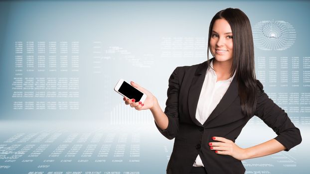 Businesswoman holding smart phone and smiling. High-tech graphs at backdrop