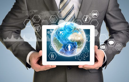 Man hands using tablet pc. Image of Earth and hexagons with icons on tablet screen. Element of this image furnished by NASA
