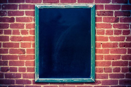 Retro Filtered Photo Of A Restaurant Menu Blackboard On A Red Brick Wall (With Copy Space)