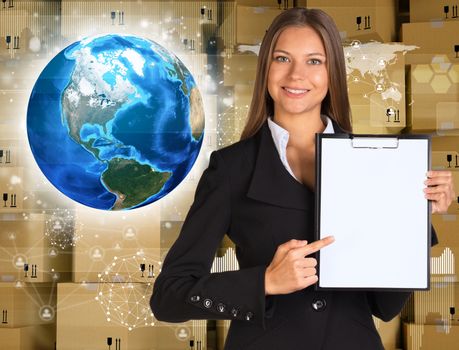 Businesswoman hold paper holder. Earth and wall of cardboard boxes as backdrop. Element of this image furnished by NASA