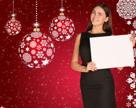 Businesswoman holding empty paper. Christmas tree balls as backdrop