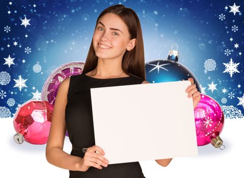 Businesswoman holding empty paper. Christmas tree balls as backdrop