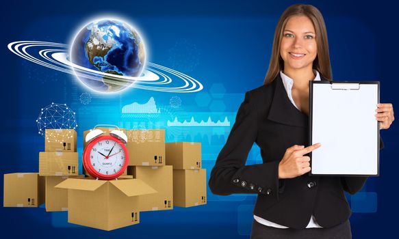 Businesswoman hold paper holder. Earth and heap of cardboard boxes with alarm clock as backdrop. Element of this image furnished by NASA