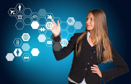 Beautiful businesswoman in suit presses finger on virtual icon. Hexagons with icons in background