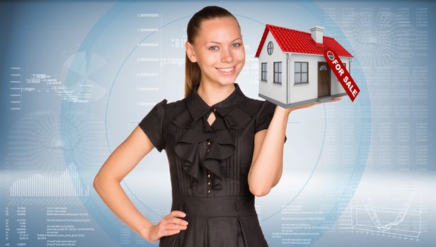 Businesswoman smiling and holding house in hand. Business concept