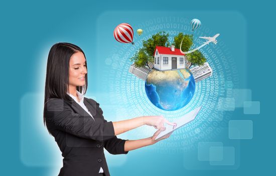 Beautiful businesswomen in suit using digital tablet. Earth with house and trees. Figures as backdrop. Element of this image furnished by NASA