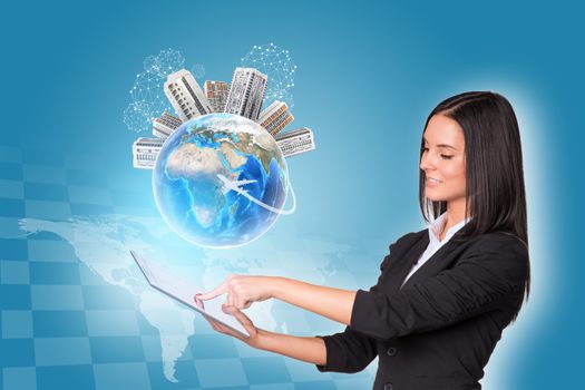 Beautiful businesswomen in suit using digital tablet. Earth with buildings. World map and chessboard as backdrop. Element of this image furnished by NASA