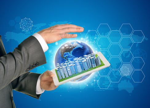 Man hands using tablet pc. Business city on touch screen. Earth as backdrop. Element of this image furnished by NASA