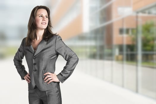 Business woman in gray suit in front of an office building