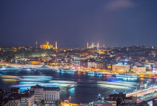 ISTANBUL - SEPTEMBER 17, 2014: City night panorama with Blue Mosque and Hagia Sophia on background. Istanbul is visited by more than 11 million people every year.