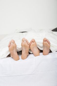 Married couples feet in bed