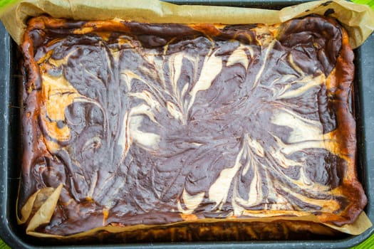 Fresh baked marble cheese cake with chocolate on cooking pan