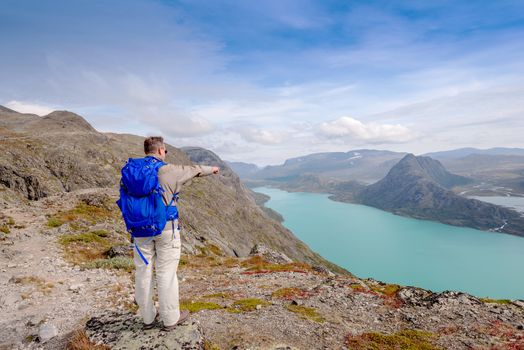 Tourist at  Besseggen pointing to Lake Gjende