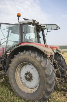 Close image of a red tractor on a field.