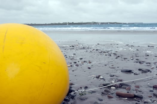 giant yellow buoy on a beach in the wild atlantic way