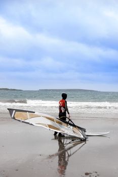 lone windsurfer getting ready to surf on the beach in the maharees county kerry ireland