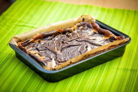 Fresh baked marble cheese cake with chocolate on cooking pan