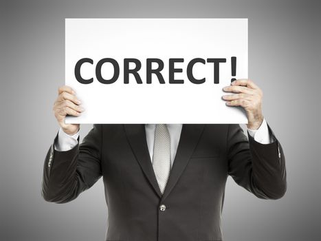 A business man holding a paper in front of his face with the text correct