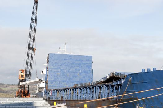 large ship being loaded with steel by crane at Youghal pier county Cork, Ireland