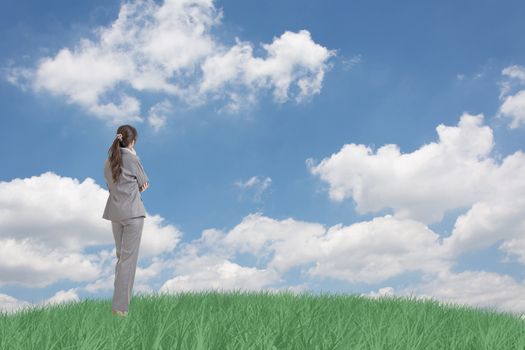 Asian business woman standing on grassland and thinking with copyspace on heaven.