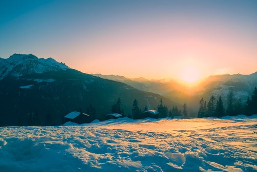 Picturesque view of sunset over snow-covered mountains in                 
