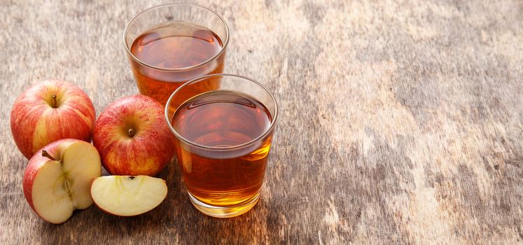 Glass of apple juice with apples on the table