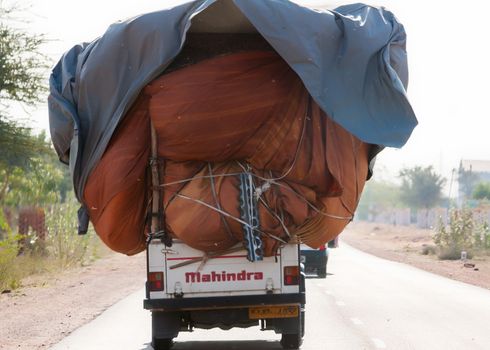 NAGAUR, INDIA - CIRCA FEBRUARY 2011: Common practice of loading a pickup truck to the max and driving it on the road.