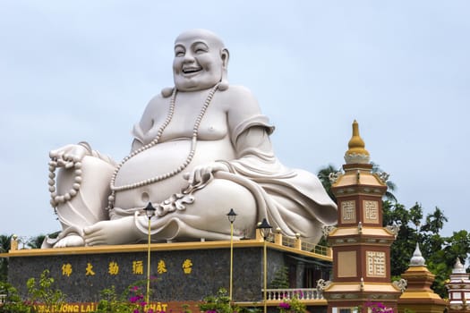 My Tho town in Mekong Delta: Massive white Sitting Buddha statue at Vinh Trang Pagoda, Vietnam.