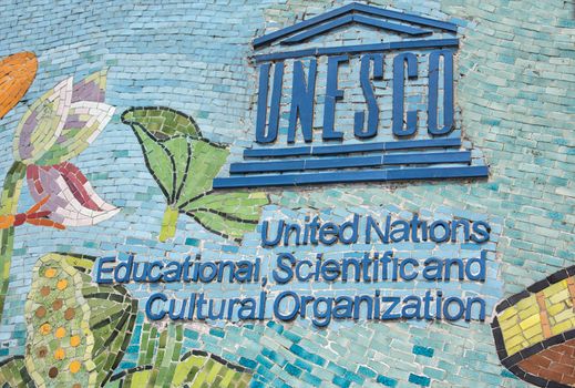 HANOI, VIETNAM - CIRCA MARCH 2012: UNESCO logo on longest mosaic wall in the world. Blue logo and name on colorful fresco.